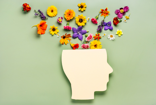 Flowers growing out of a head silhouette symbolizing mental health