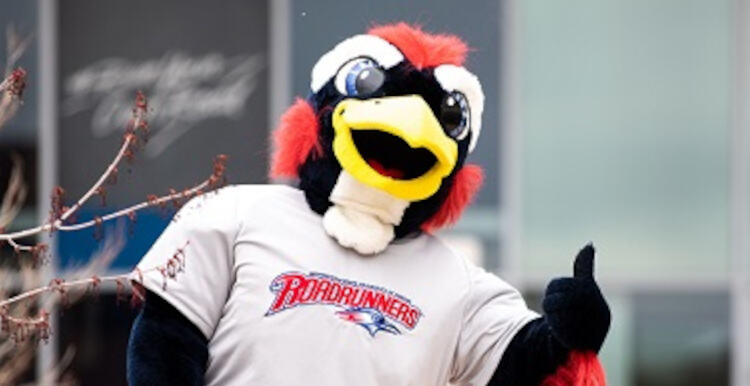 Rowdy giving thumbs up and standing in front of Student Success Building.