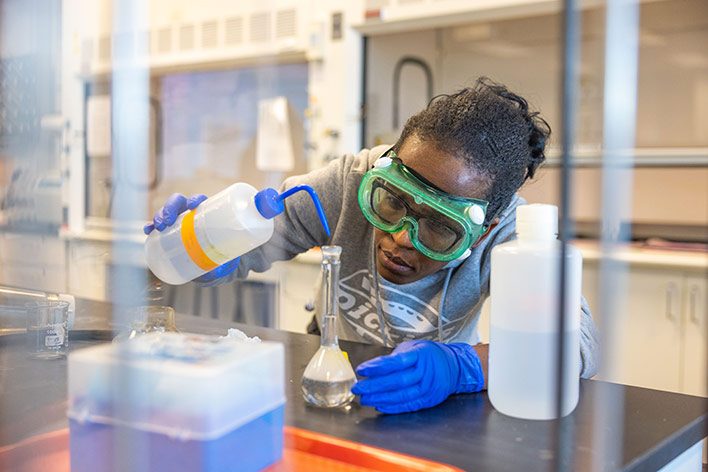 MSU Denver chemistry student works in a lab.