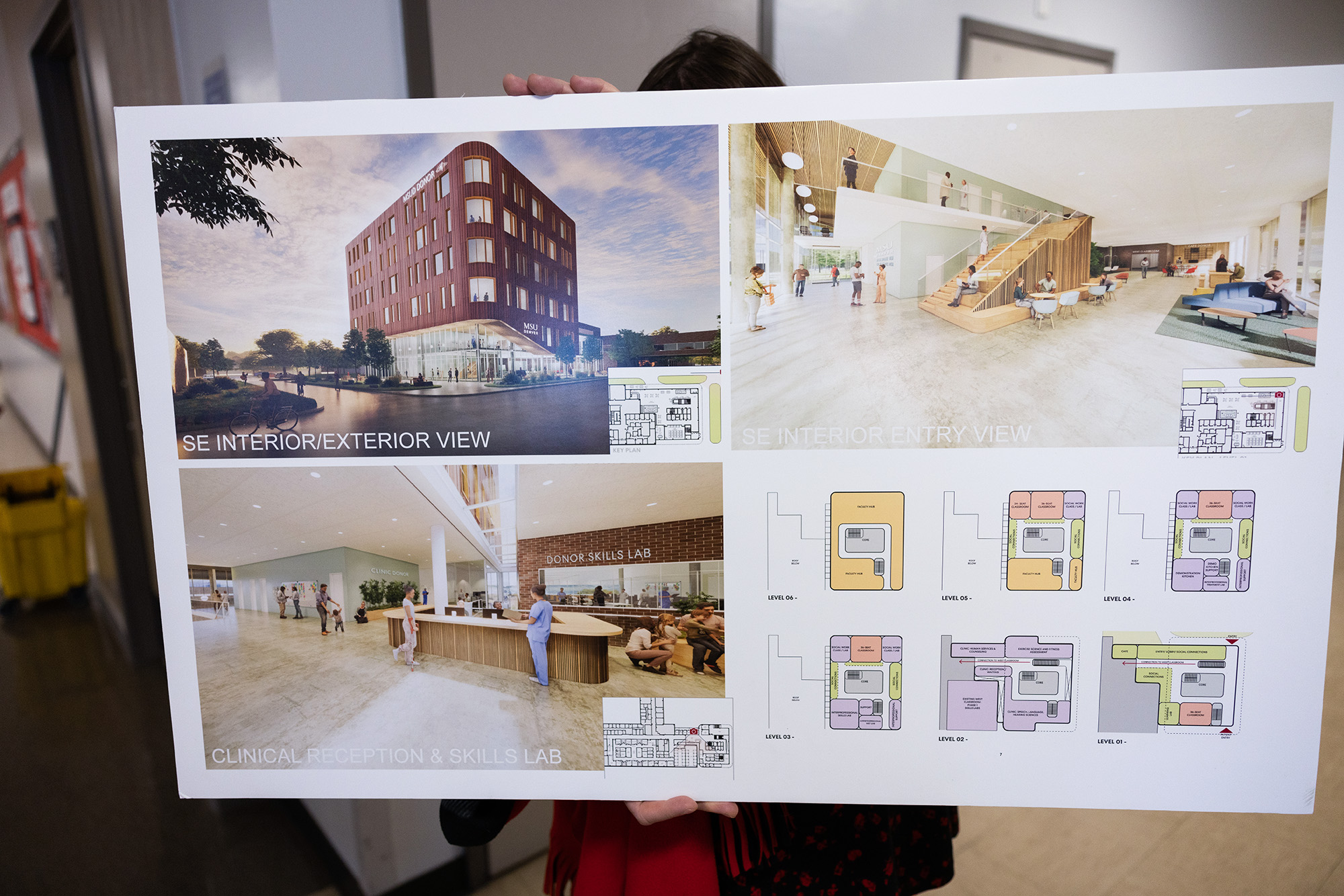 A person holds a poster displaying conceptual drawings of MSU Denver's planned Health Institute.