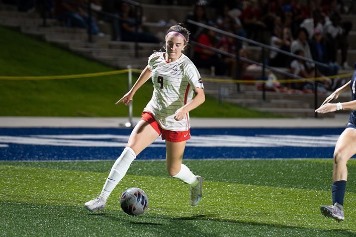 MSU Denver soccer player dribbles the ball.