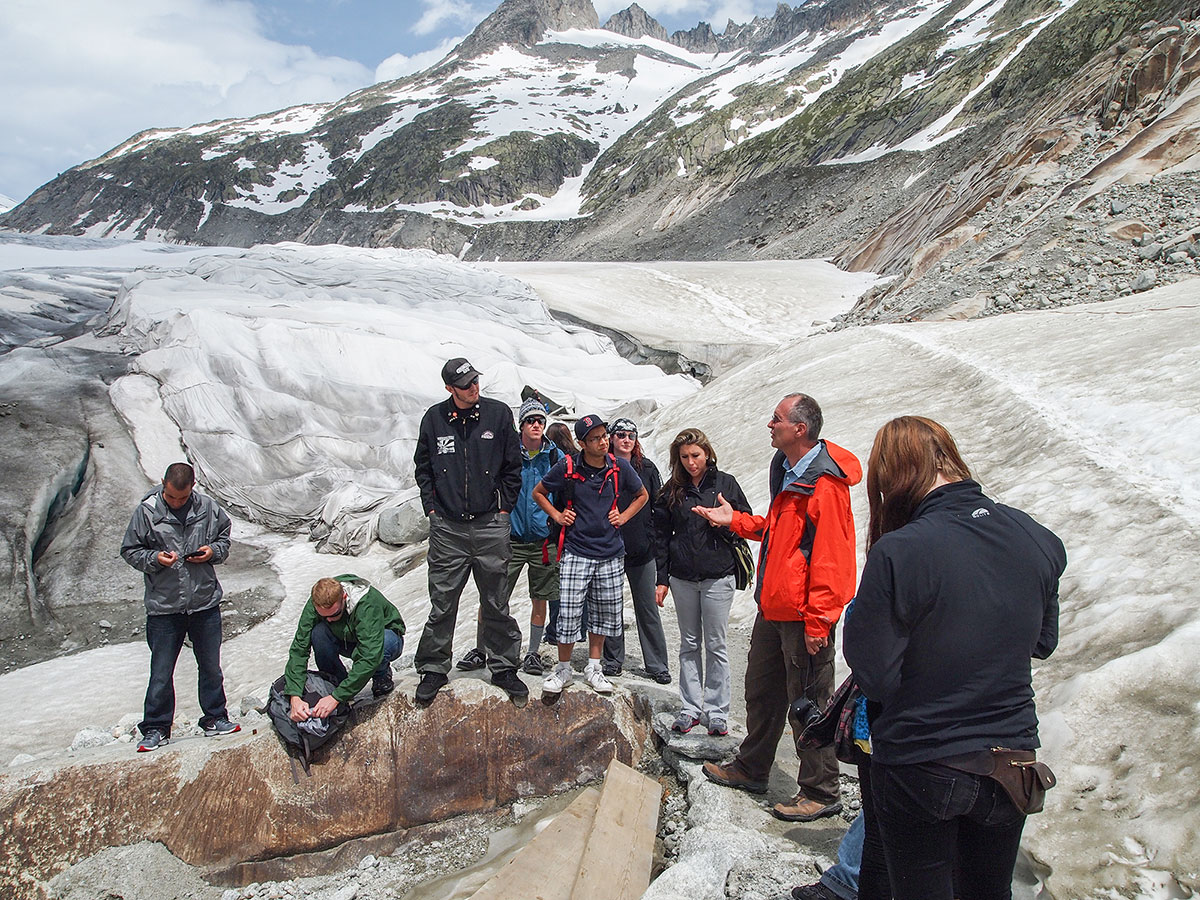 Geology Professor Uwe Kackstaetter talks with students at Switzerland's Rhone Glacier.