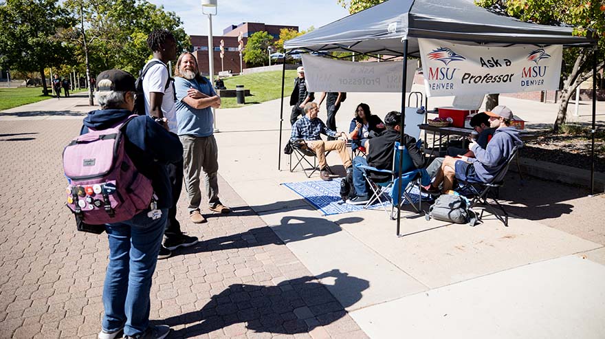 MSU Denver history professor Matthew Makley, left, talks with a student while Robert Preuhs sits a group of students during the first Ask A Professor event