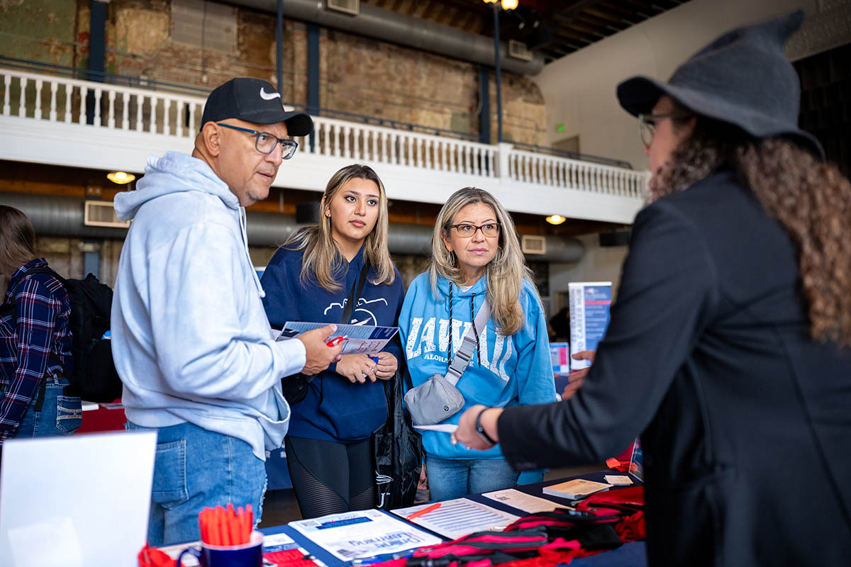 Family interacting with an admissions representative at an MSU Denver open house event.