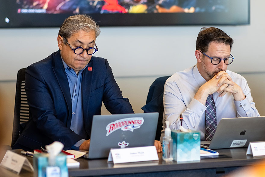 MSU Denver Chief Strategy Officer James Mejia and Dean John Masserini sit at a conference table as they participate in a President's Cabinet meeting.