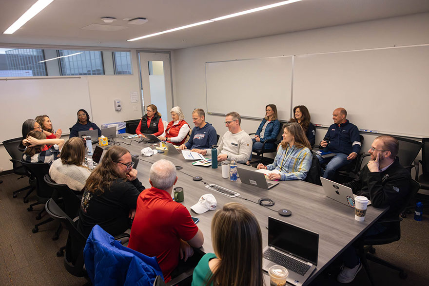 Members of a budget committee at MSU Denver sit around a large conference table.