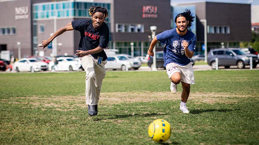 Students playing soccer outside
