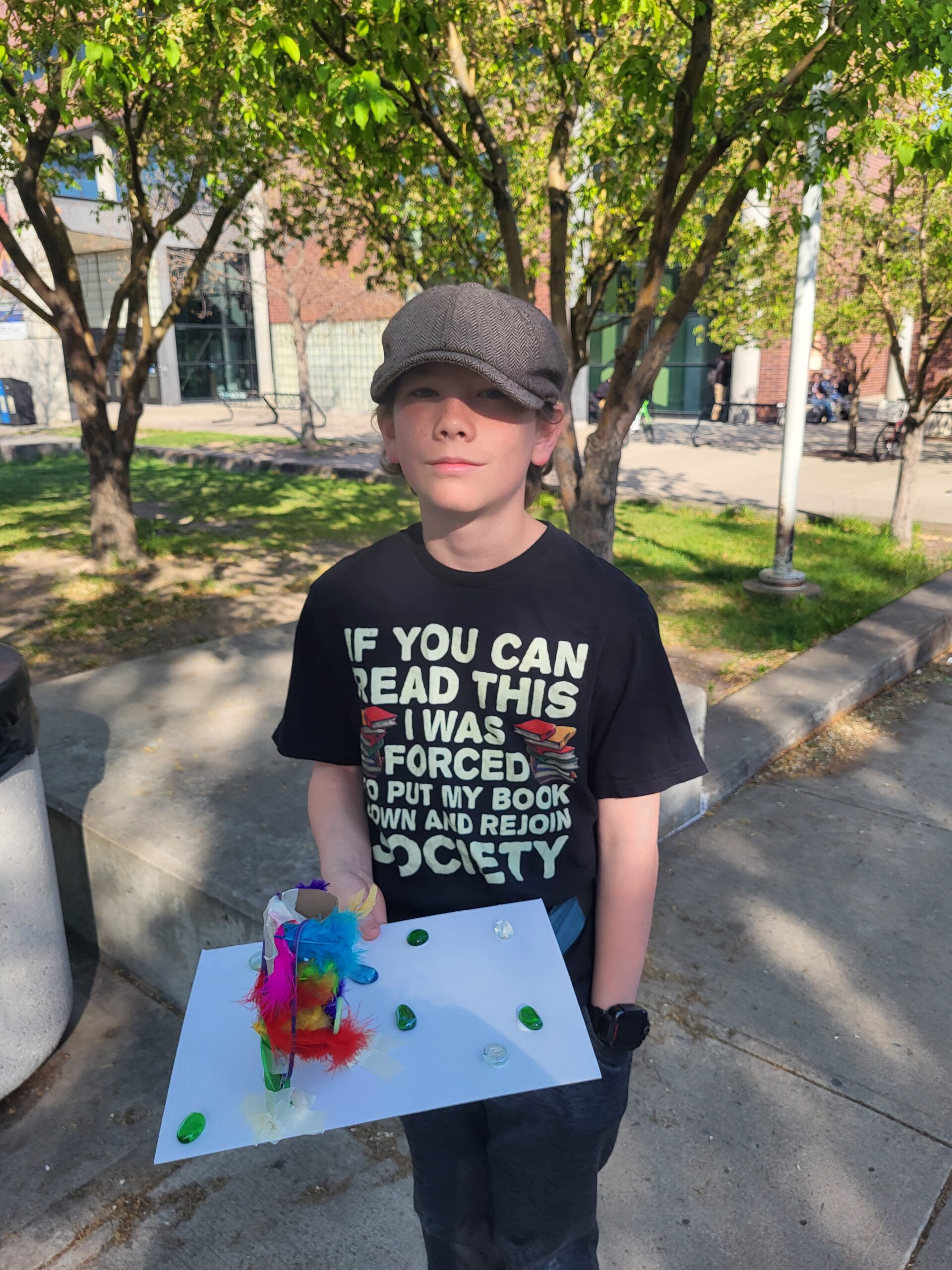 A child displays their craft project on Bring a Child to Work Day.