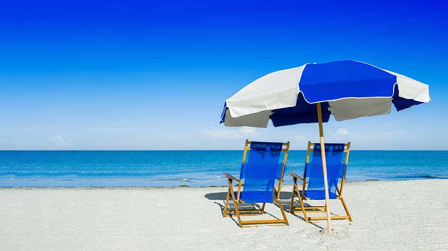 sun loungers and a beach umbrella on silver sand, vacation concept