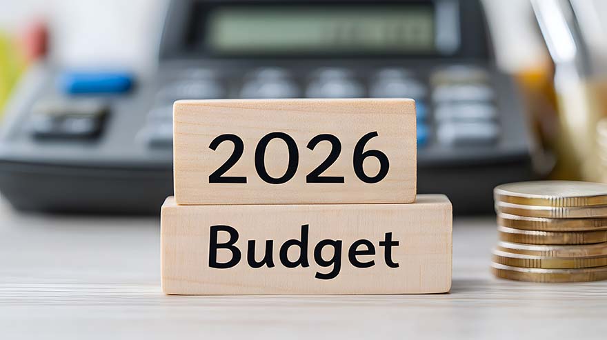 2026 Budget' spelled out on wooden blocks alongside coins and calculator