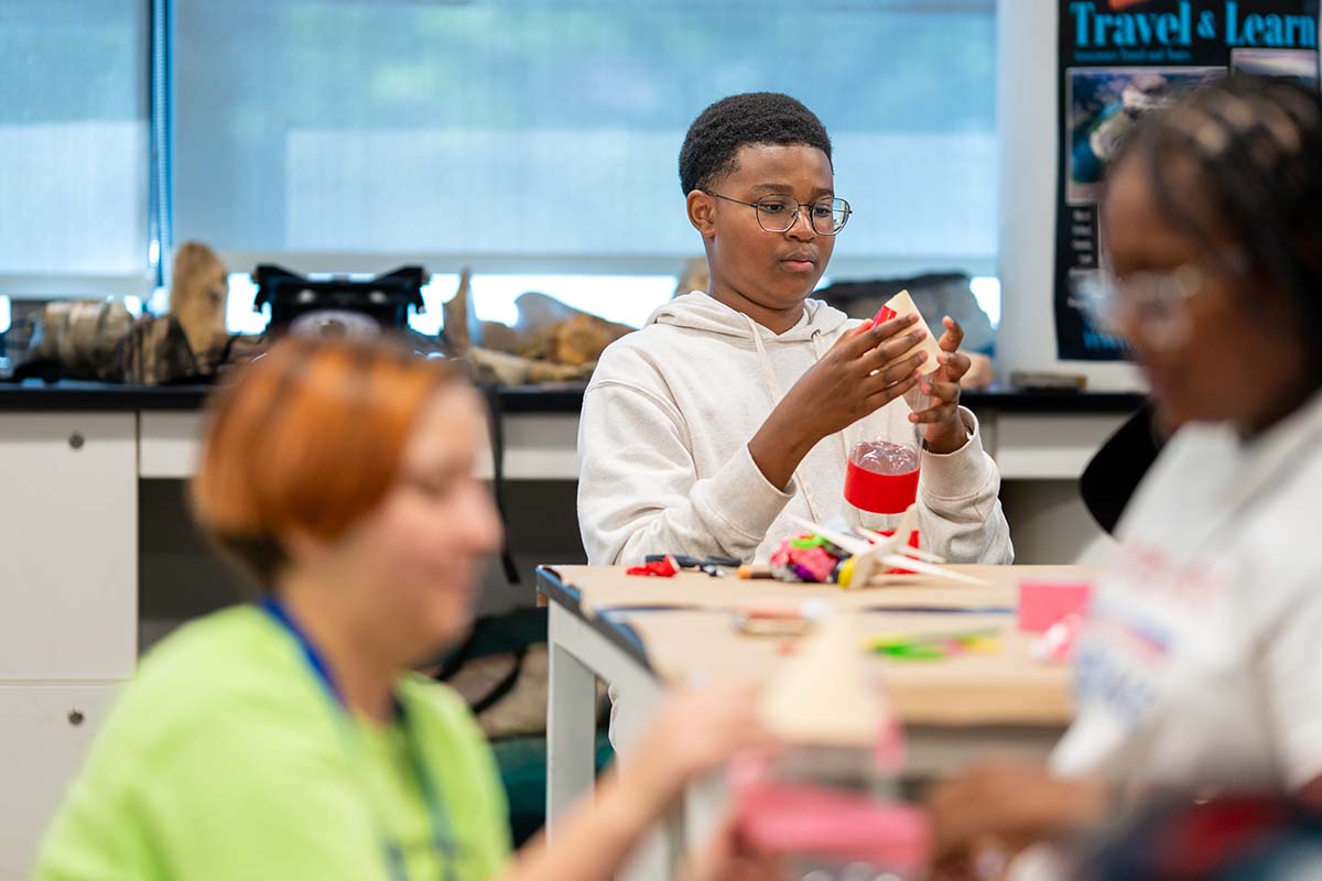 MSU Denver Summer Science Institute student Kaleb Dapa attaches the cone to his water rocket