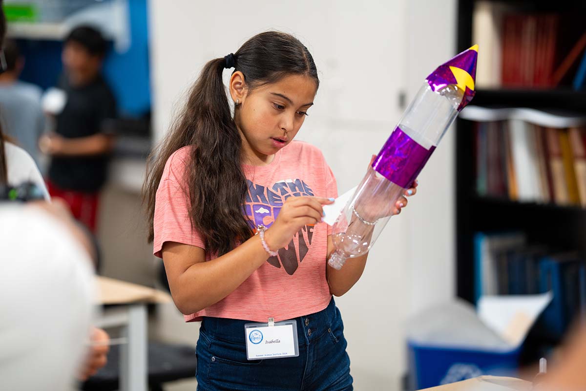 MSU Denver Summer Science Institute student Isabella Lerma attaches fins to her rocket.