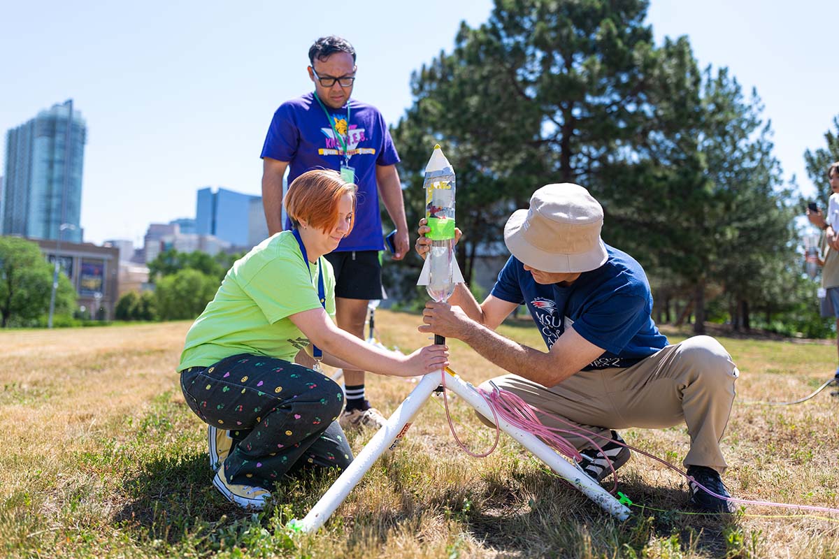 Summer Science Institute leaders prepare rockets for launch.
