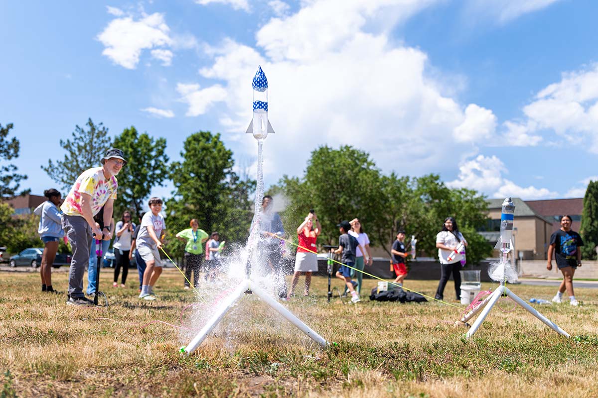 Summer Science Institute students launch their rockets outside