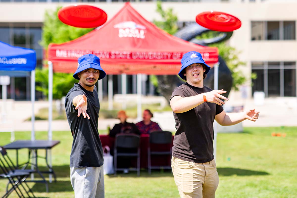 Students play frisbee at convocation