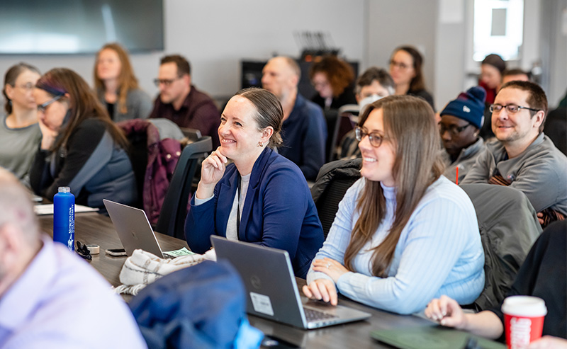 Faculty and staff members at MSU Denver sit together in a classroom during a Faculty Senate meeting