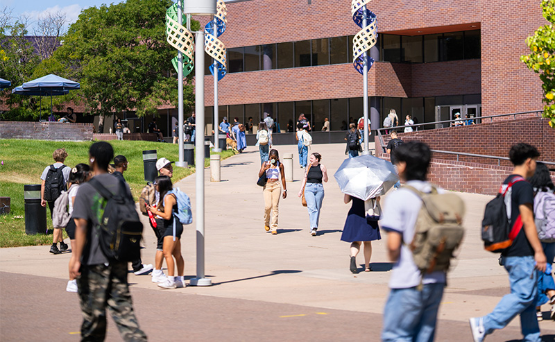 Students walk across a busy outdoor area on the Auraria Campus