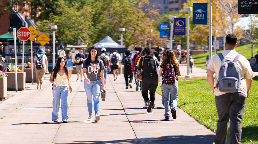 Students walk along the main campus walkway at MSU Denver on a sunny day.
