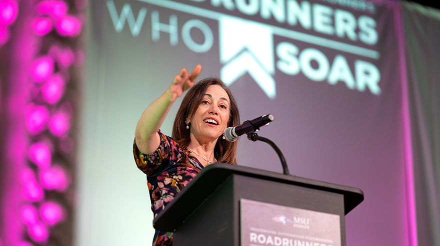 MSU Denver President Janine Davidson speaks at the podium during the 2024 Roadrunners Who Soar event, addressing university community members