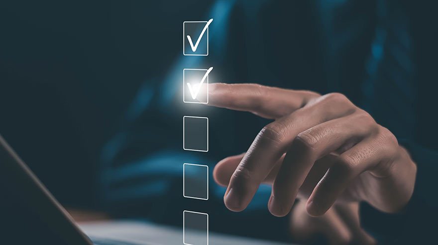 Illustration of a hand checking off a box in front of a computer.