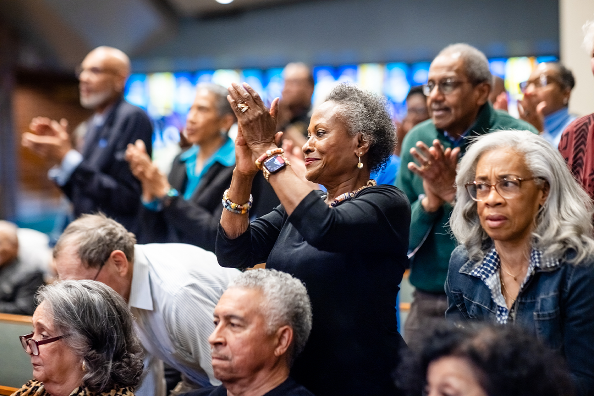 Audience members stand and applaud during the Rachel B. Noel community event.