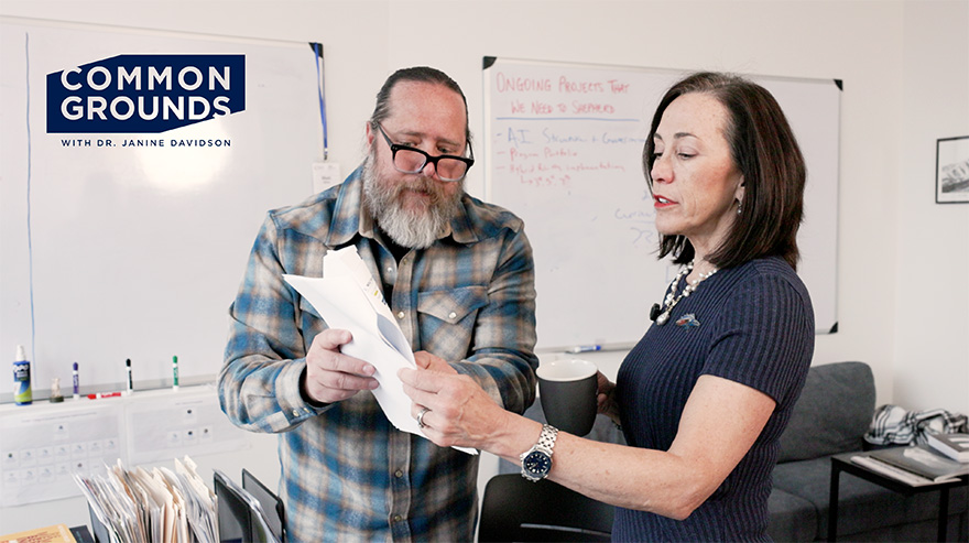 MSU Denver President Janine Davidson and Provost Matt Makley inspect papers they are holding while standing in a well lit office.