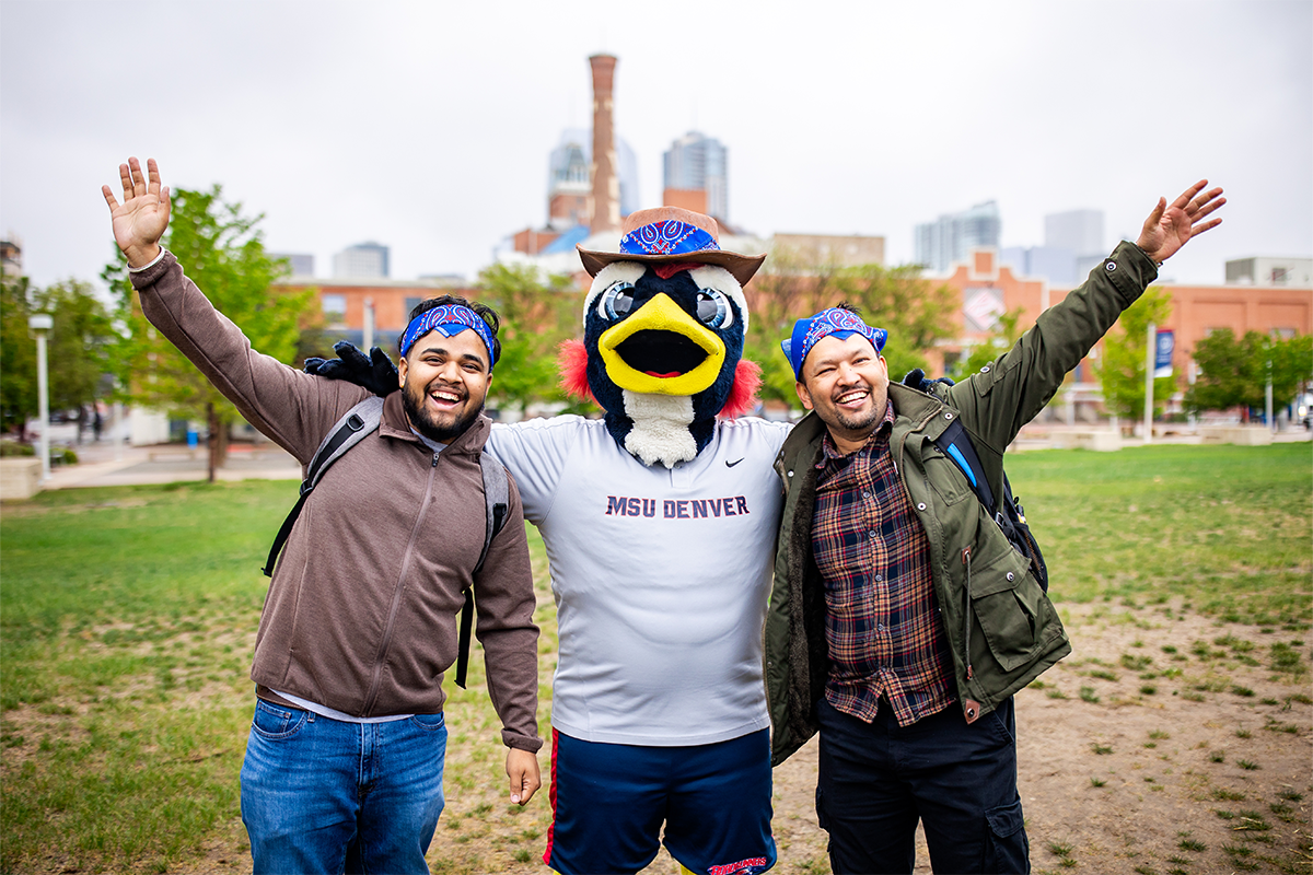 Two MSU Denver community members posing with the Rowdy mascot outdoors during the Spring 2026 Howdy Rowdy BBQ event at the JSSB Lawn.