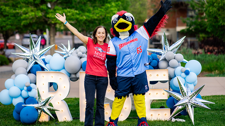 President Davidson and Rowdy pose infront of a "RISE" sign.