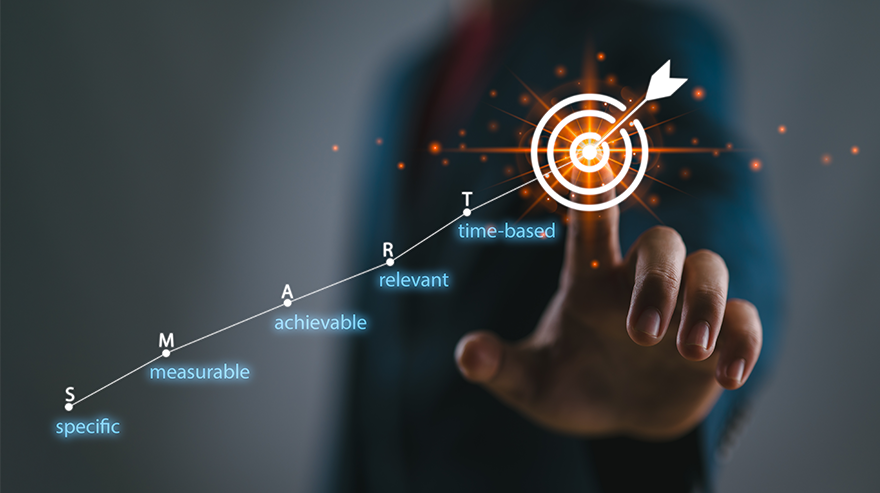 Graphic overlaying a person's finger touching an illustration of a target and arrow also includes a depiction of the acronym "SMART" with the words specific, measurable, achievable, relevant and time-based.
