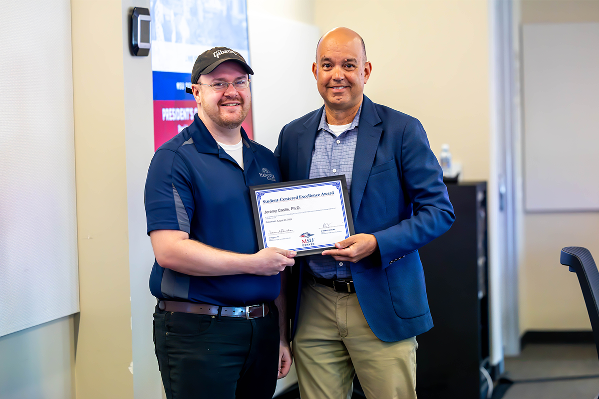 Jim Carpenter, interim president and CFO, presents an award to Jeremy Castle, professor of Political Science.