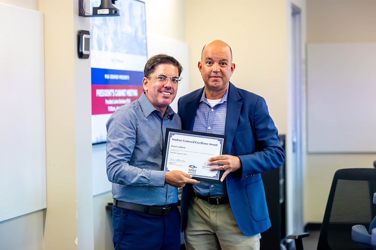 Jim Carpenter, interim president and CFO, presents a Student-Centered Excellence Award to Shaun LaBarre, director of the Institute for Public Service.