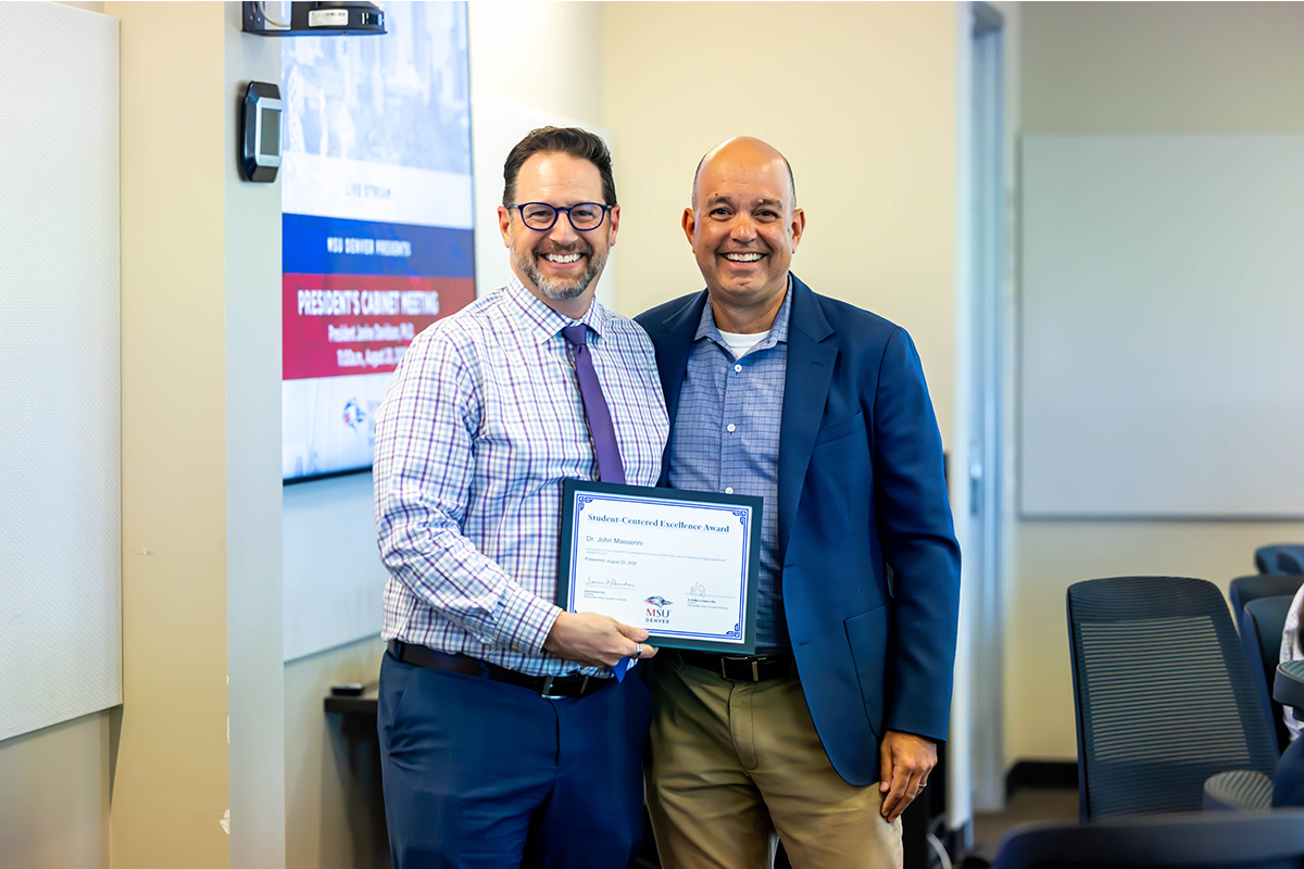 Jim Carpenter, interim president and CFO, presents a Student-Centered Excellence Award to John Masserini, Ph.D.