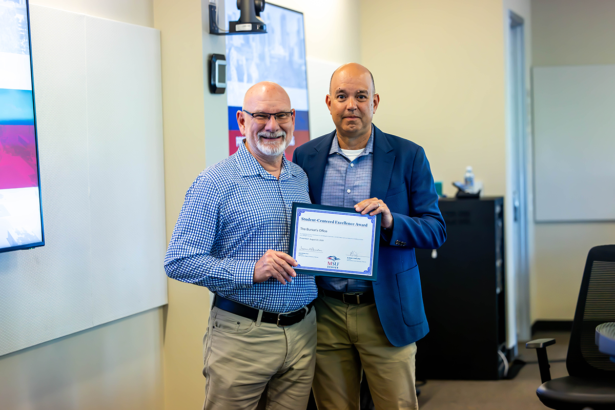 Jim Carpenter, interim president and CFO, presents a Student-Centered Excellence Award to Mike McCabe