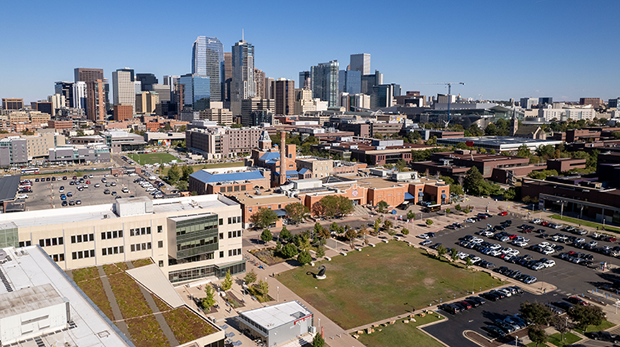 An aerial shot shows the MSU Denver campus with the Denver skyline in the background