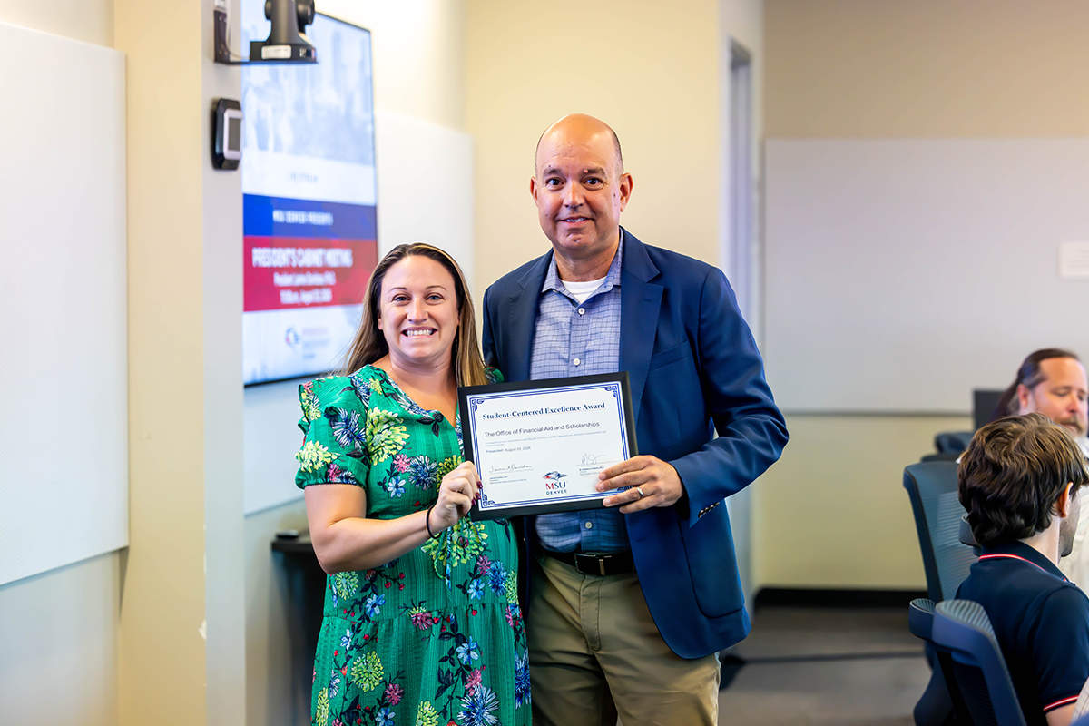 Jim Carpenter, interim president and CFO, presents a Student-Centered Excellence Award to Kelly Findley, associate director of scholarships, and the Office of Financial Aid and Scholarships.