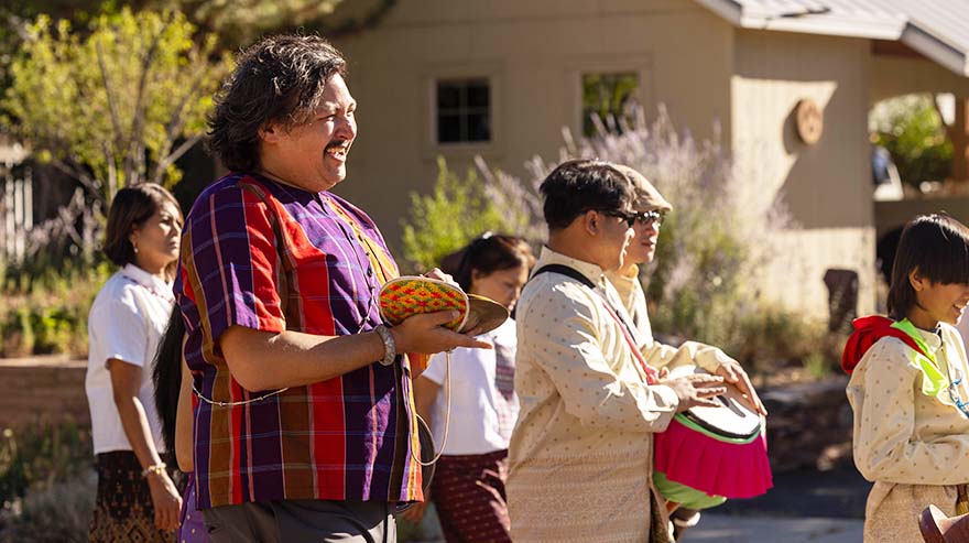 Music affiliate faculty member Benjamin Pongtep Cefkin plays the chap, cymbals, in an ordination ceremony at the temple