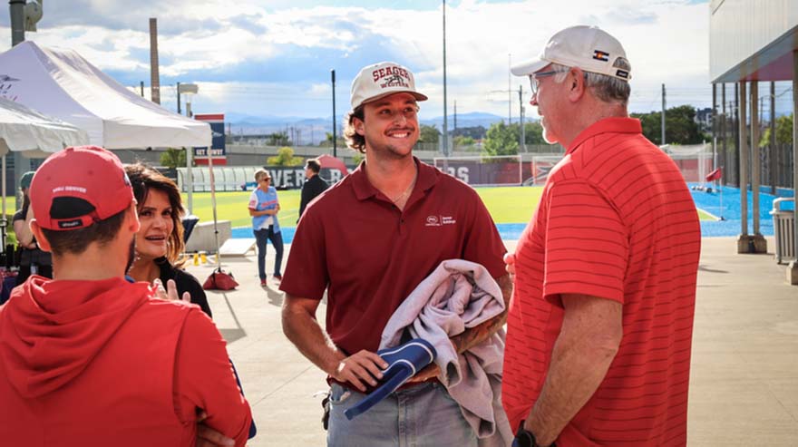 Alum Owen Reynolds talks with Director of Athletics Todd Thurman at the tailgate.