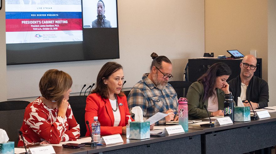 Four President's Cabinet members surround President Janine Davidson as she speaks from a seat at the meeting table
