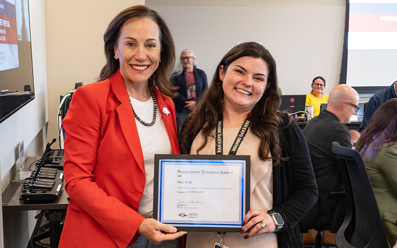 President Janine Davidson poses for a photo with Elex Ertel as both hold a Roadrunner Shoutout Award plaque addressed to Ertel